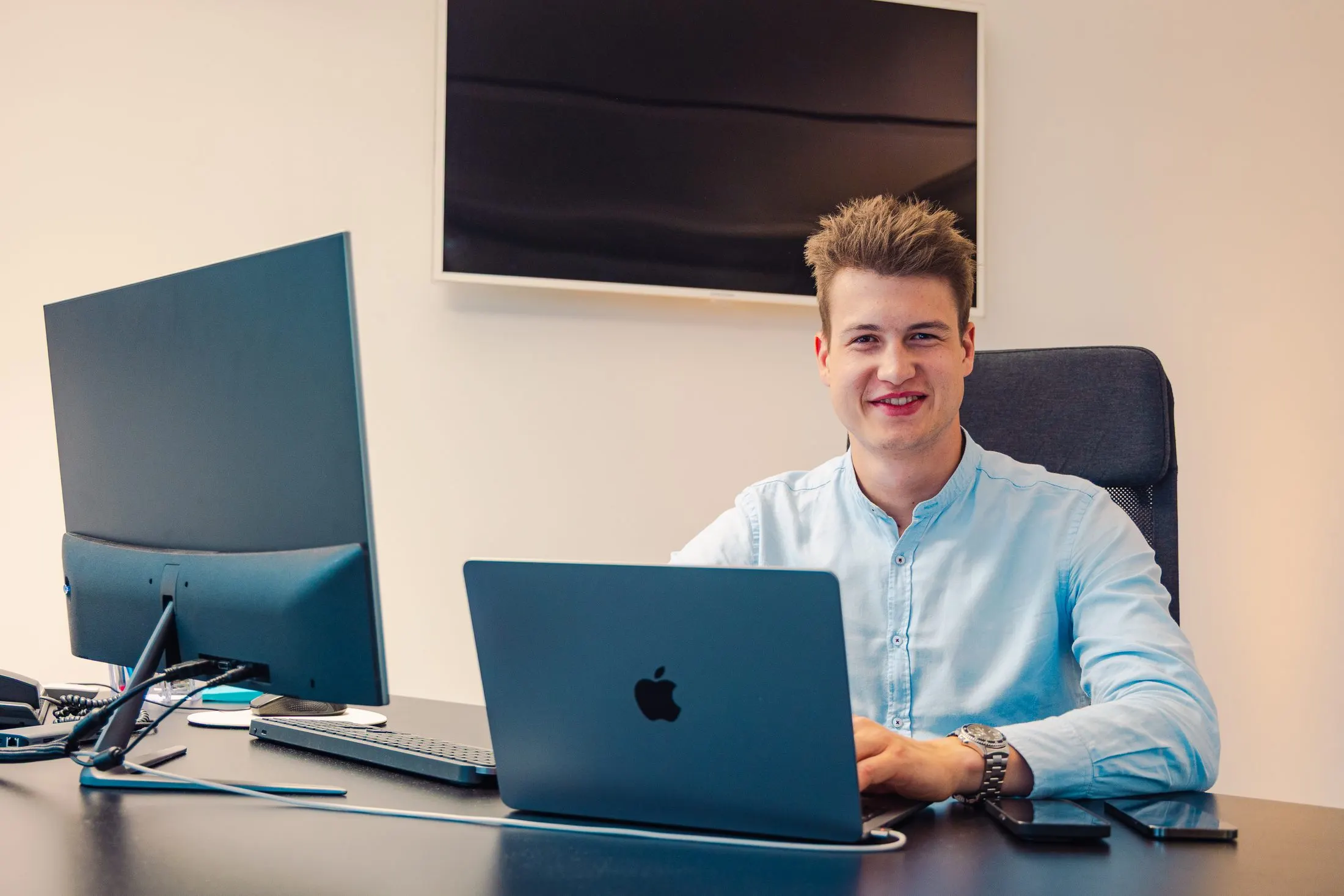 Kaino-Entwickler an seinem Arbeitsplatz mit Laptop und Monitor