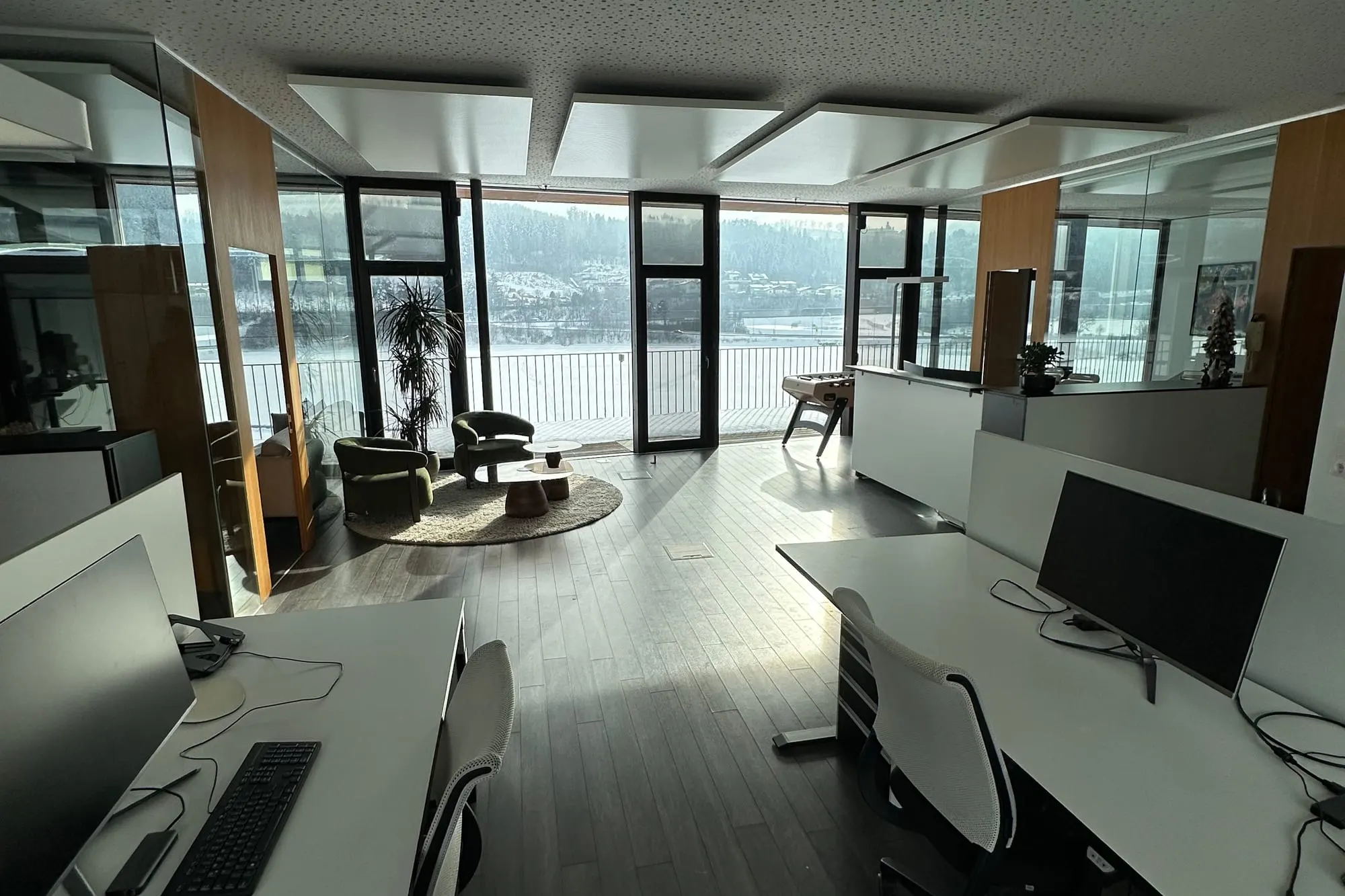 Blick durch das Kaino-Büro auf die Schreibtische mit Monitoren, dahinter die Fensterfront